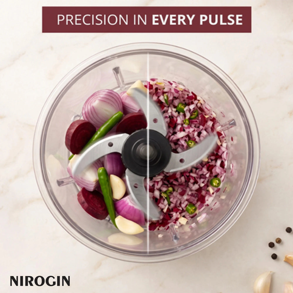 Nirogin rechargeable vegetable chopper with chopped vegetables and herbs inside a clear bowl.